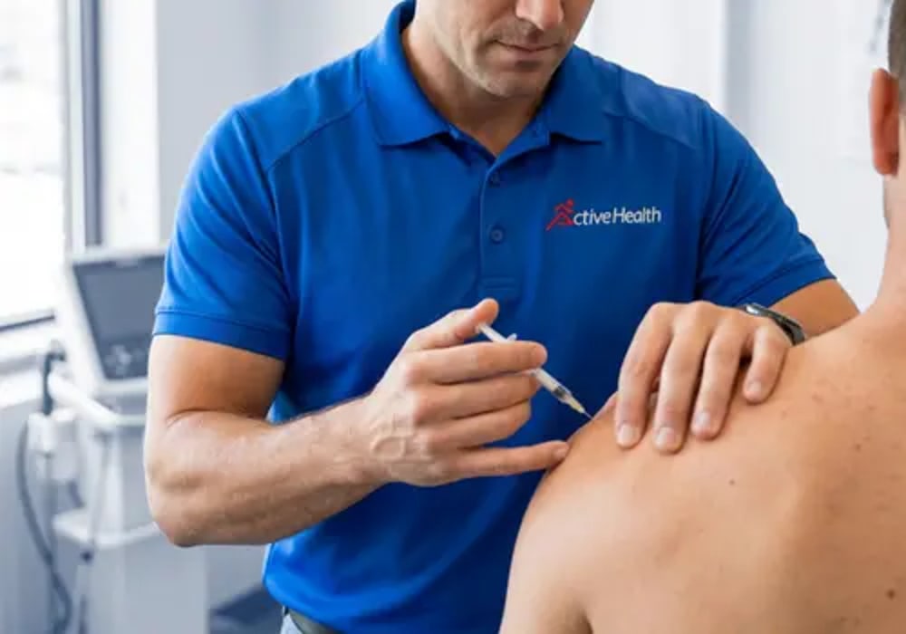 Active Health clinician delivering a precision guided injection to a patient's shoulder in the Jacksonville clinic